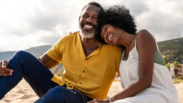 older woman and man in laughing on the beach