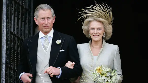 King Charles III and Queen Camilla standing outside a church