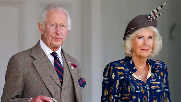 King Charles III and Queen Camilla standing outside in coats