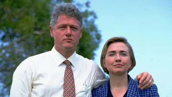 Bill Clinton with his arm around Hillary Clinton