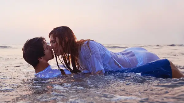 couple kissing in the ocean