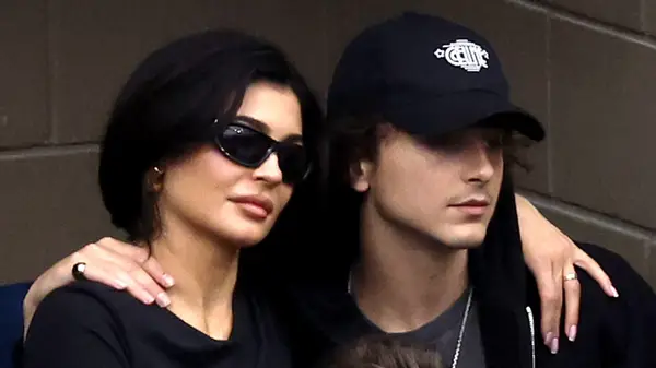 Kylie Jenner and Timotheé Chalamet in bleachers with their arms around one another