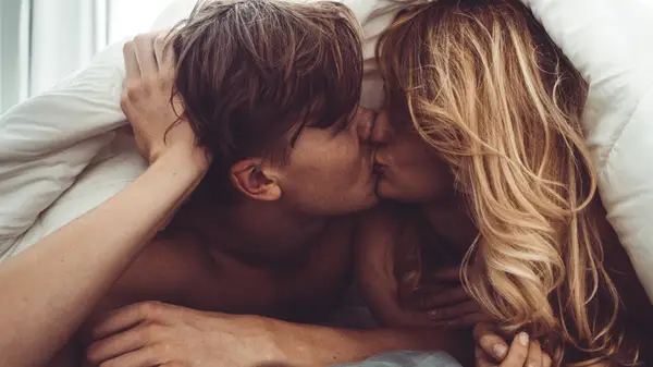 couple kissing in bed