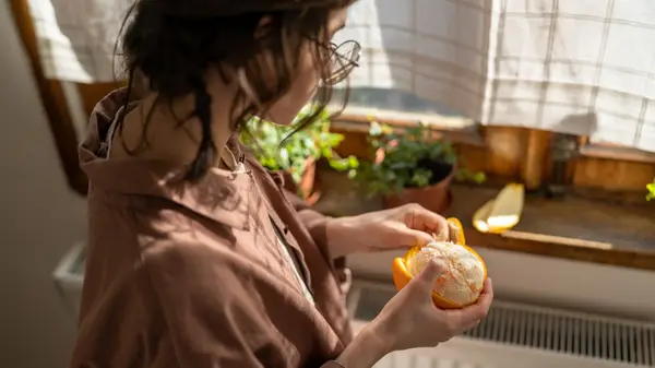 Woman peeling orange