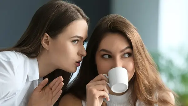 two women gossiping together