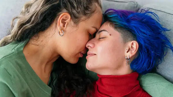 Queer couple embracing each other on a couch