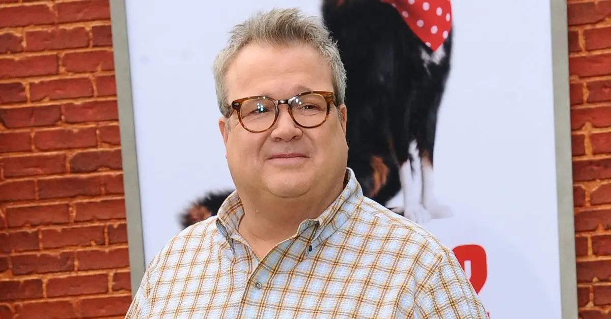 포스터 앞에서 웃고 있는 Eric Stonestreet
