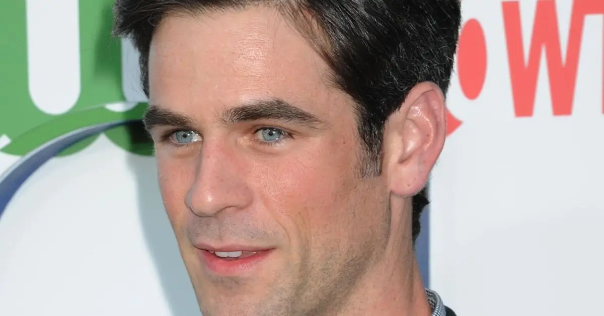 Eddie Cahill souriant sur le tapis rouge d'un événement