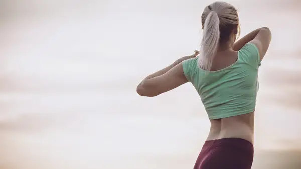 back of woman arms bent torso stretch