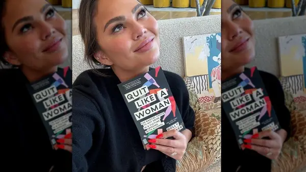 Chrissy Teigen holding book Quit Like A Woman