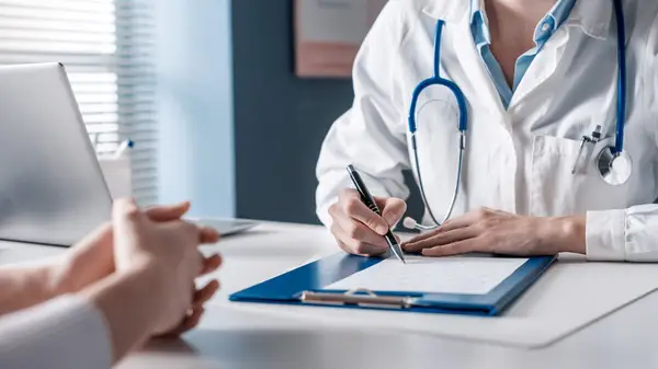 surgeon writing on pad at desk