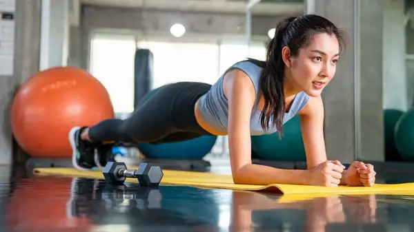 A woman doing a plank at the gym