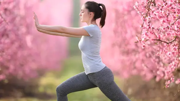 Woman doing tai chi outside 