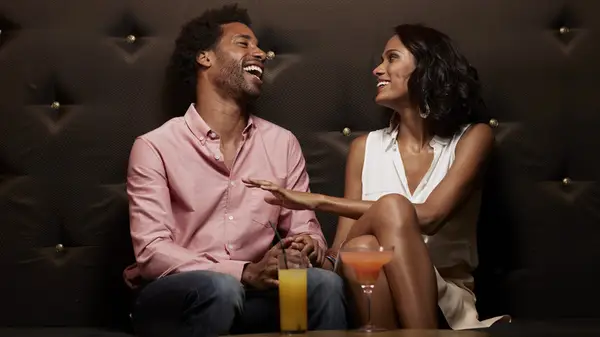 Couple laughing while drinking at club