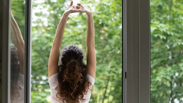 Woman with back turned stretching outside 