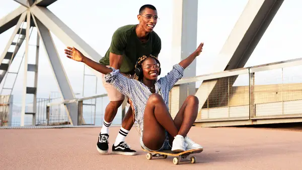 Man pushing girl on skateboard