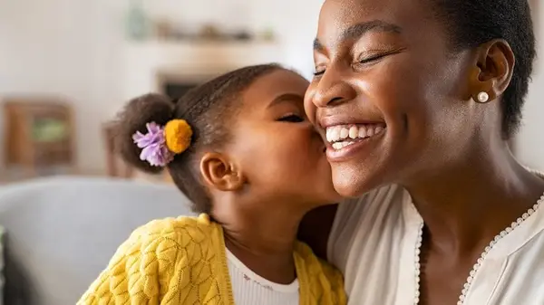 Daughter giving mother kiss on cheek