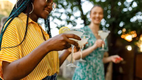Women outside holding cocktails