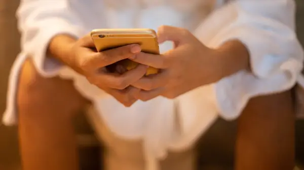 Person looking at phone on toilet