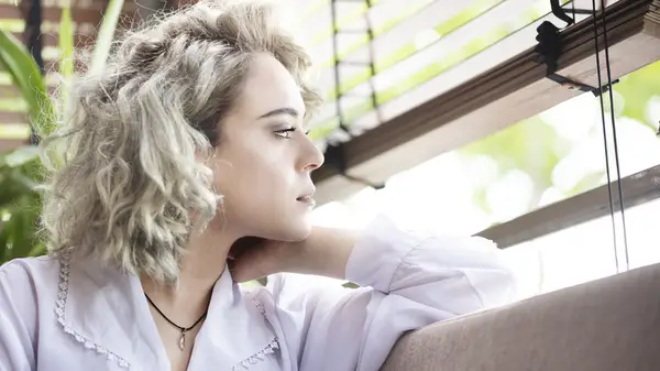 Tired-looking woman gazing out window