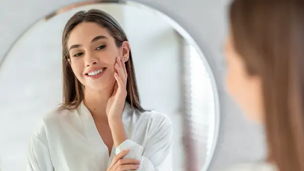 Woman caressing face in mirror
