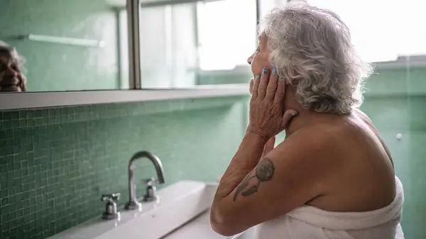Older woman looking in mirror