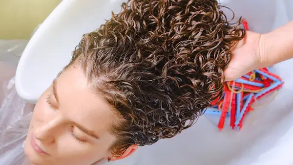 Curly-haired woman getting her hair washed