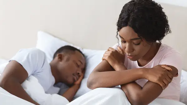 Sad woman in bed with man