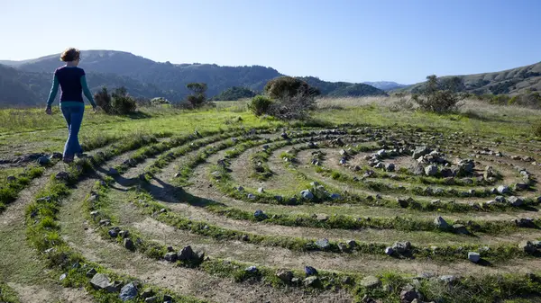 Woman walking in spiral made from stones