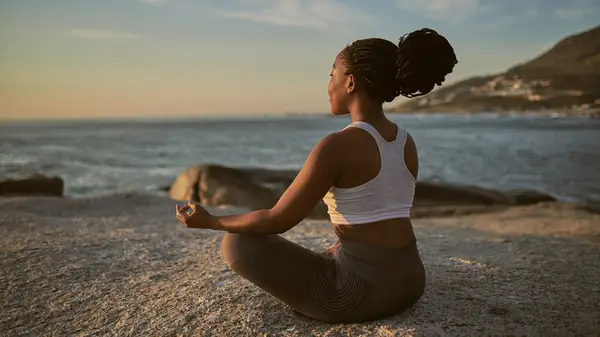 Woman meditating on the beach