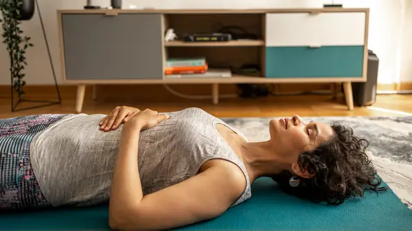 Woman lying on floor meditating 