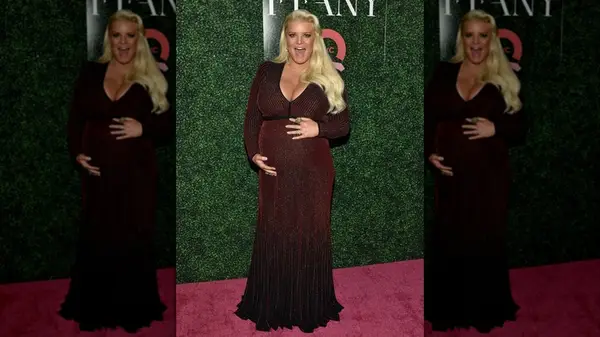 Jessica Simpson holding her baby bump on the red carpet in 2018