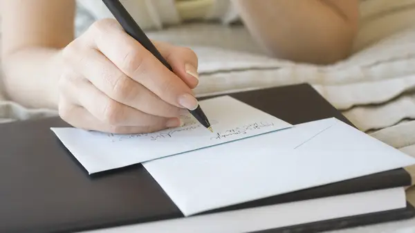 A person writing a letter