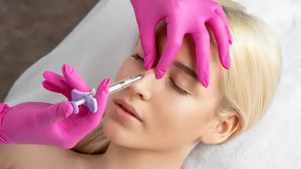 Woman getting injection in nose