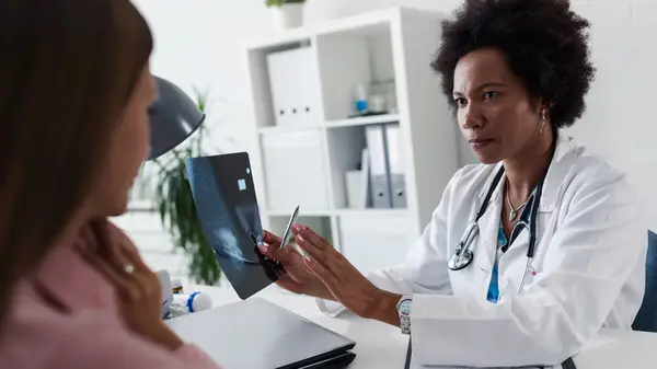 Doctor speaks to patient while looking at scan