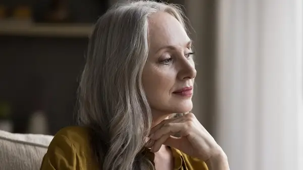 Mature woman looking out window