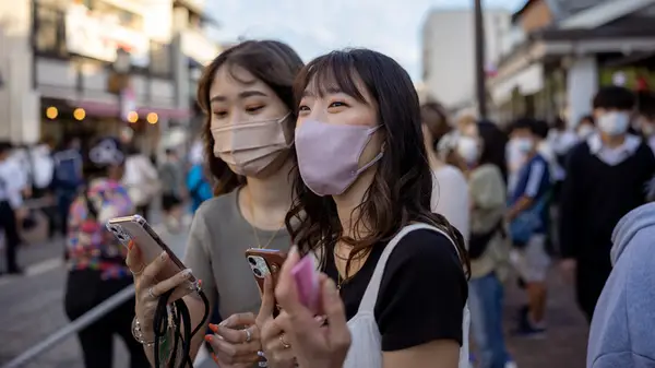 Women wearing a mask at a festival