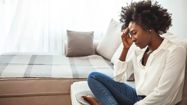 Woman looking overwhelmed on couch