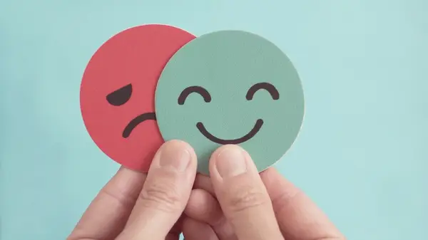 person holding happy and sad face