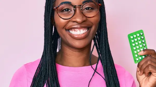 smiling woman holding birth control