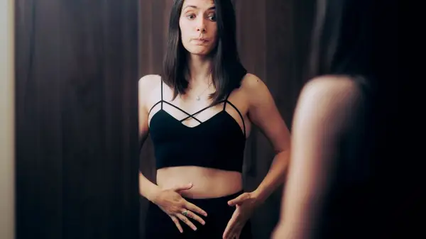 Woman looking concerned in mirror