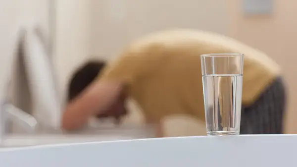 Person bent over toilet bowl