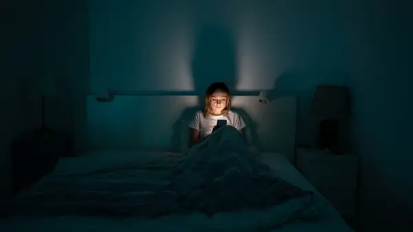 woman in bed on phone