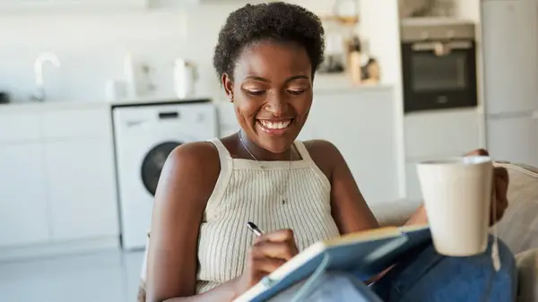 Woman journaling with cup of tea